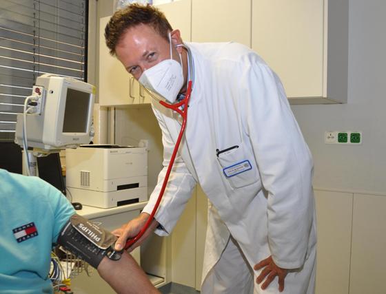Prof. Dr. Martin Schmidt kontrolliert den Blutdruck eines Patienten. Foto: kk/sf