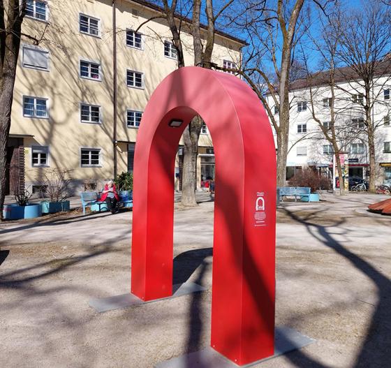 Bis Ende April steht das Wahrzeichen der Stadtteilmarke "Ramersdorf  Daheim in der Stadt" - ein roter Torbogen - als großformatiger Logoaufsteller auf dem Karl-Preis-Platz. Foto: MGS München