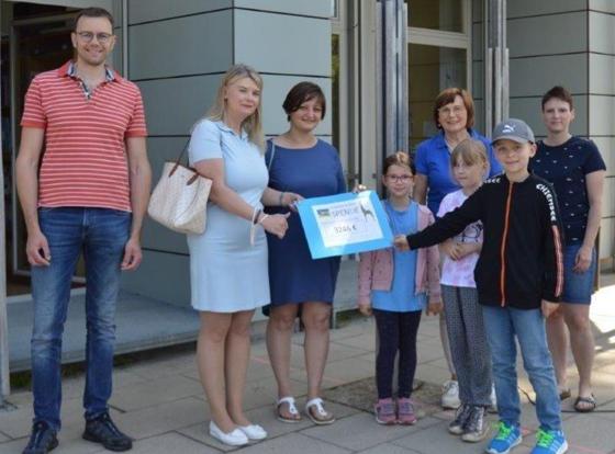 Die stolzen Schüler der Grundschule Hochbrück übergaben einen Spendenscheck an die Vertreter des Helferkreises Garching. Foto: Grundschule Hochbrück