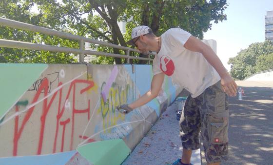 Der Graffitikünstler Benjamin Calliari-Herzberg verschönert derzeit die Fußgängerbrücke am Kusocinskidamm. Am Wochenende soll das Kunstwerk fertig sein. Foto: bas
