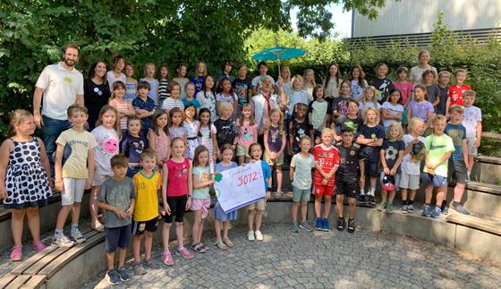Zur Spendenübergabe kam KlinikClown Dr. Willi Schmarrn (mit Schirm) an die Ernst-Reuter-Grundschule. Foto: Ernst-Reuter-Grundschule