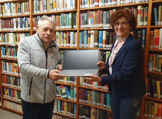 Einrichtungsleiterin Christiane Igl übergibt dem neuen Bibliothekar den Laptop. Foto: Petra Sachs
