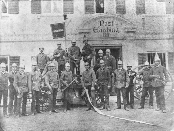 Mit Trompete und Schlauch: Stolz präsentiert sich die Feuerwehr-Mannschaft samt Spritzenwagen 1883 vor dem Gasthaus Post. Foto: FFW Garching
