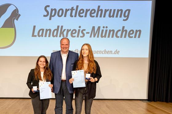 Landrat Christoph Göbel überreicht an Michelle Frank (l.) und Hannah Gasser (r.) vom FC Aschheim die verdienten Auszeichnungen. Foto: Robert Kinderle