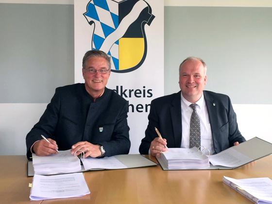Garchings Erster Bürgermeister Dr. Dietmar Gruchmann und Landrat Christoph Göbel unterzeichnen im Landratsamt den Kaufvertrag (v.l.). Foto: LRA