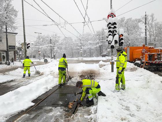 Unter Einsatz aller Kräfte befreien die Mitarbeiter der Stadtwerke die Tramschienen meterweise von Schnee und Eis. Die Tram 19 ist bereits wieder in Betrieb. Foto: SWM
