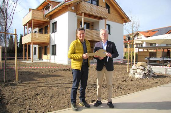 Bürgermeister Jan Neusiedl (r.) freute sich über die Schlüsselübergabe für vier neue Gemeindewohnungen durch Architekt Alexander Steininger. Foto: Gemeinde Grünwald