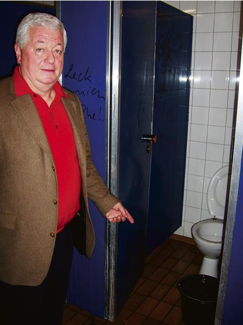 Dr. Peter Riedner, Schulleiter des Gymnasiums, zeigt in einem der übel riechenden Toilettenräume auf einen Eimer, der tropfendes Wasser aufsammelt (l.). Foto: sd