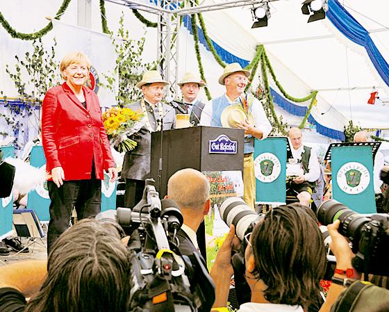 Angela Merkel, Klaus Korneder, Markus Grenzdörffer und Klaus Rieger (v.li.) freuen sich über die »Angie«-Rufe aus dem Zelt-Publikum. Foto: Föll	