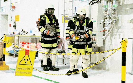 Vorsichtsmaßnahmen an einem heiklen Ort: Mitglieder der Feuerwehr Hochbrück überprüfen die Halle auf austretende Radioaktivität.	Foto: ba