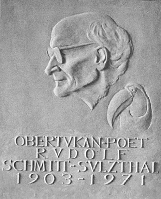 Erinnerungstafel an Rudolf Schmitt-Sulzthal in der Leopoldstraße 74, entworfen von Oswald Malura, und Tukan-Signet von Michael Jungheim	Fotos. VA