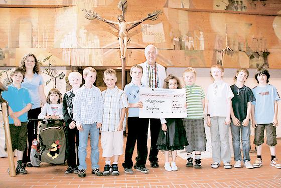 Erich Bayer bei der Scheckübergabe mit den Kindern der Pfarrei Maria Königin. Foto: Privat
